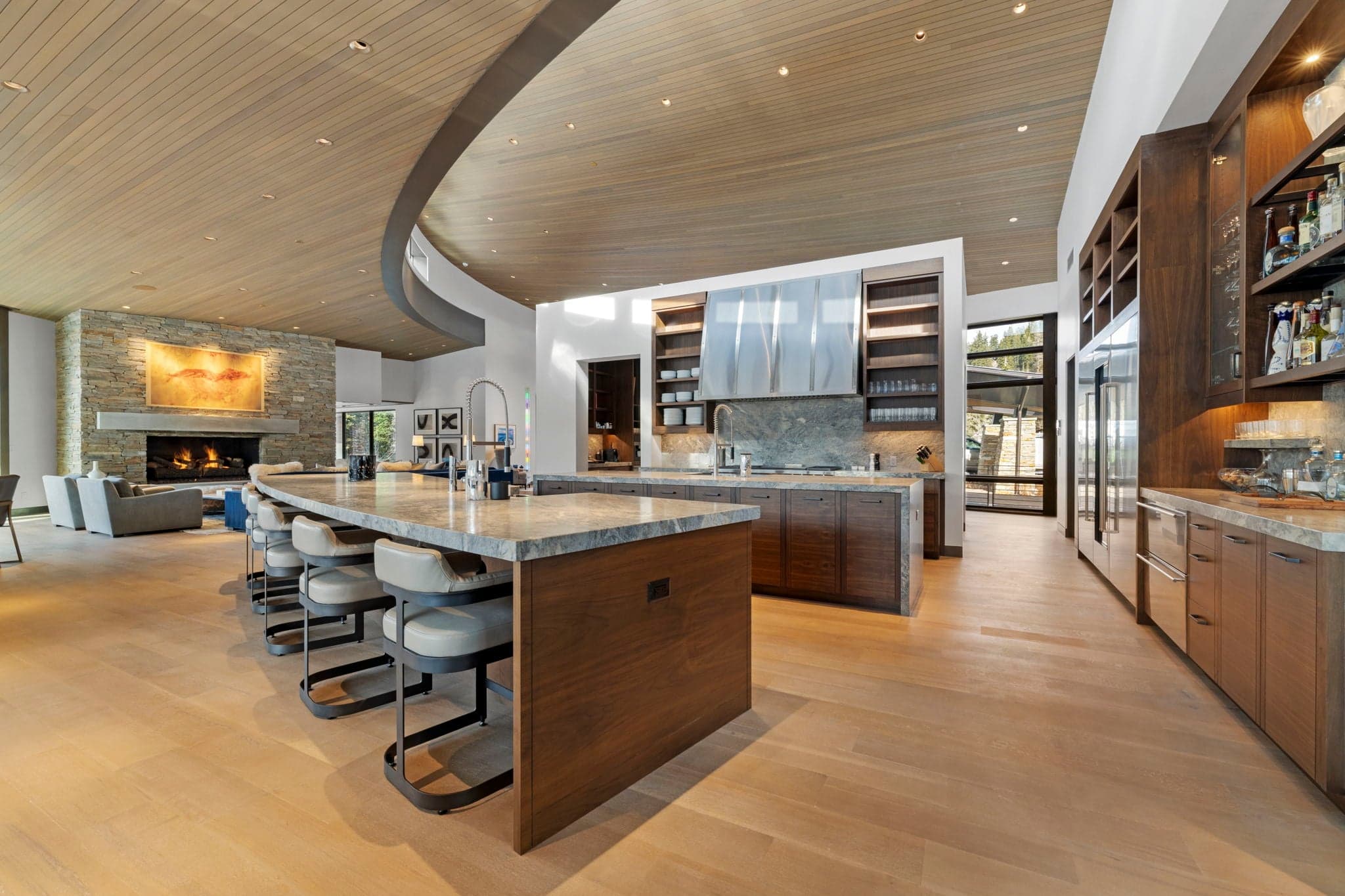 A view of the kitchen with a bar and chairs.