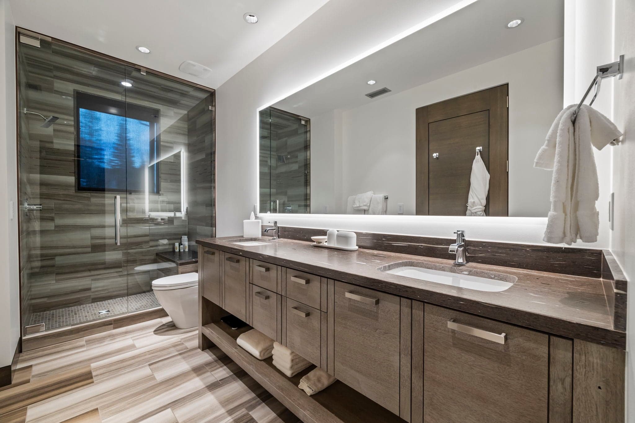 A large modern bathroom with two sinks and a shower.