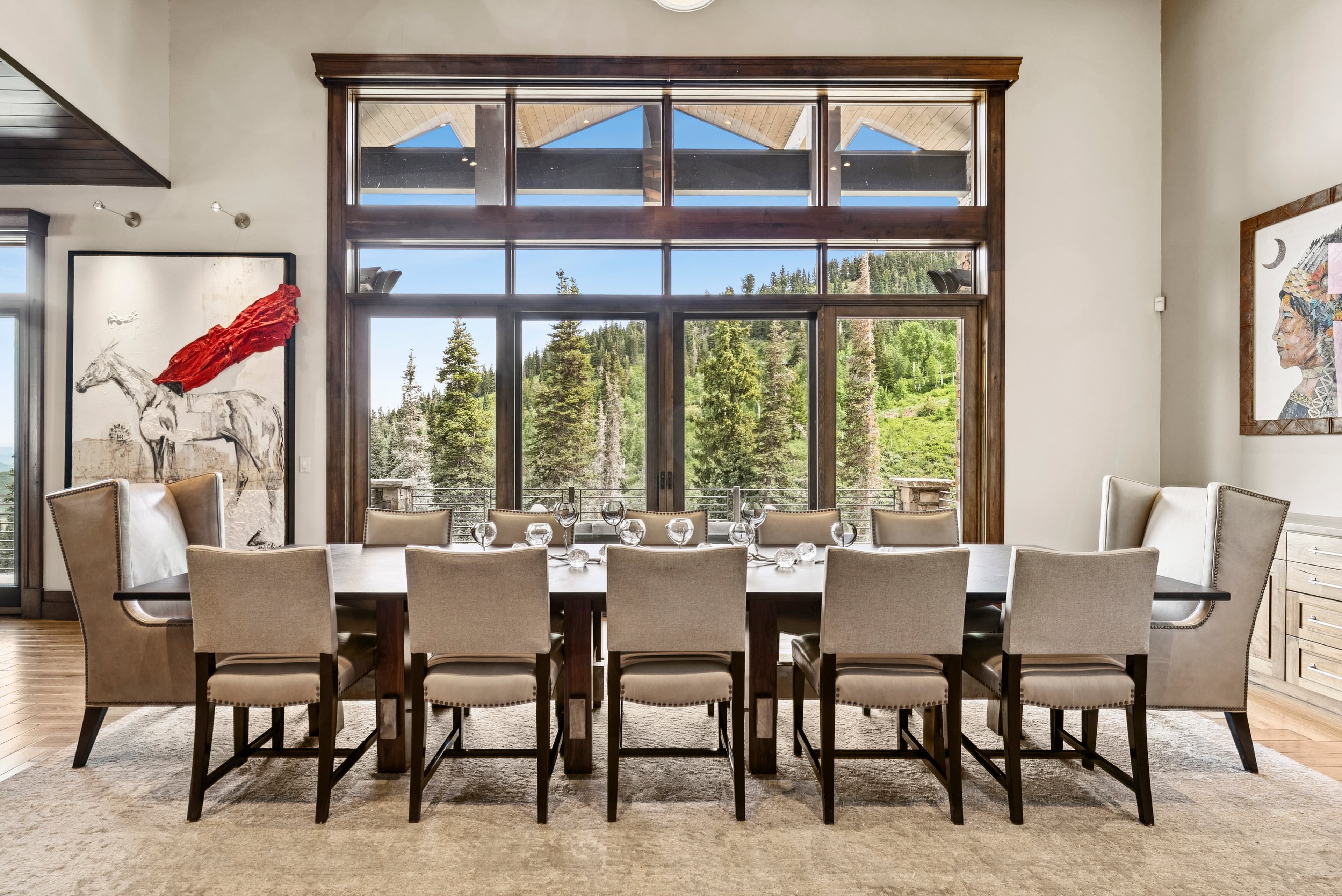 long dining room table with striking custom artwork on the walls and large views overlooking the mountains